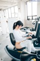 A woman sitting on a stationary bike in a gym.