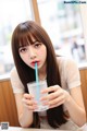 A woman sitting at a table with a glass of water.