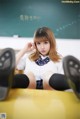 A young woman sitting on top of a yellow table.