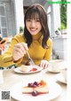 A woman sitting at a table with a plate of food.