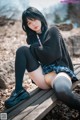 A woman sitting on a wooden bench in a park.