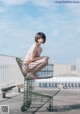 A woman in a bikini sitting in a shopping cart.