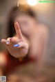 A woman with a blue manicure is making a peace sign.