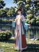 A woman in a kimono standing in front of a lake.